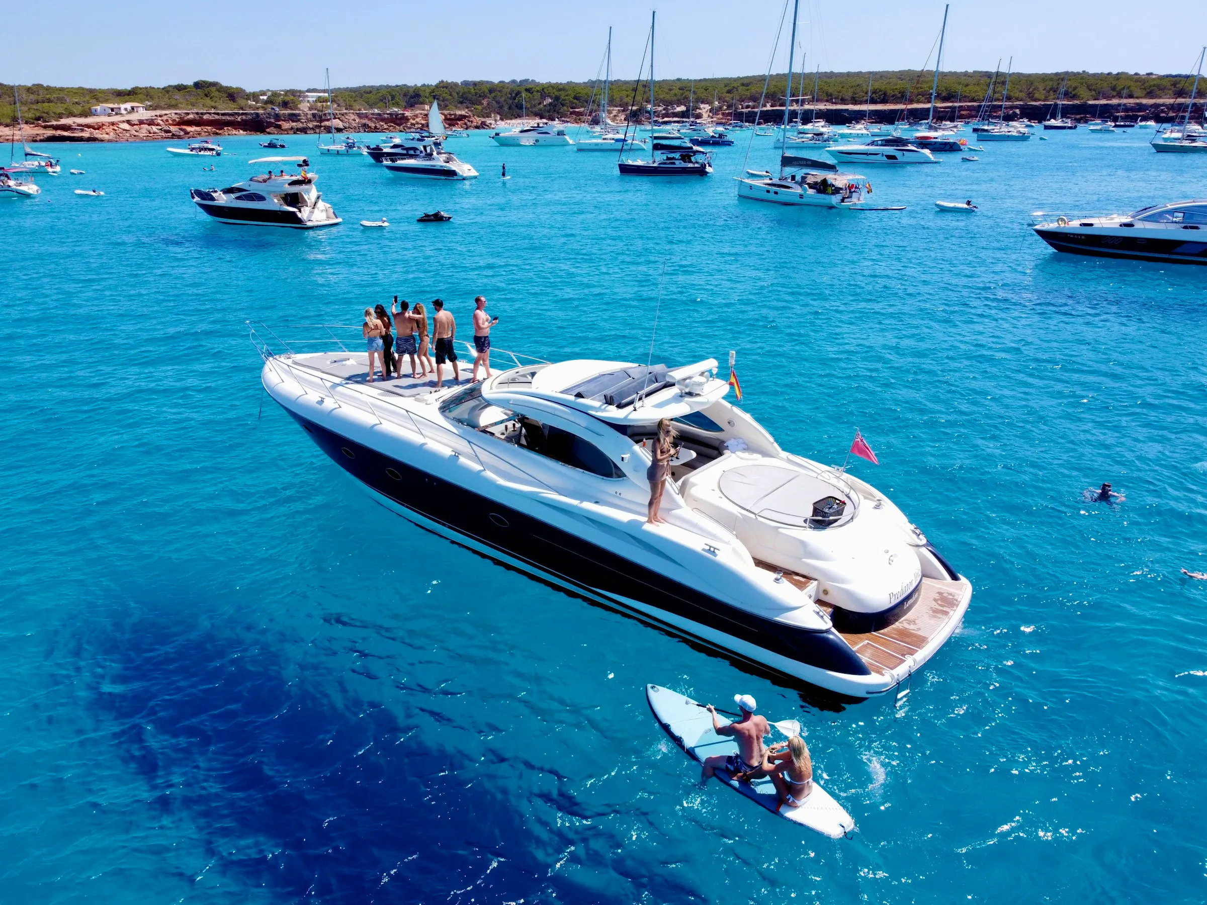 Group gathered on a yacht deck in turquoise waters
