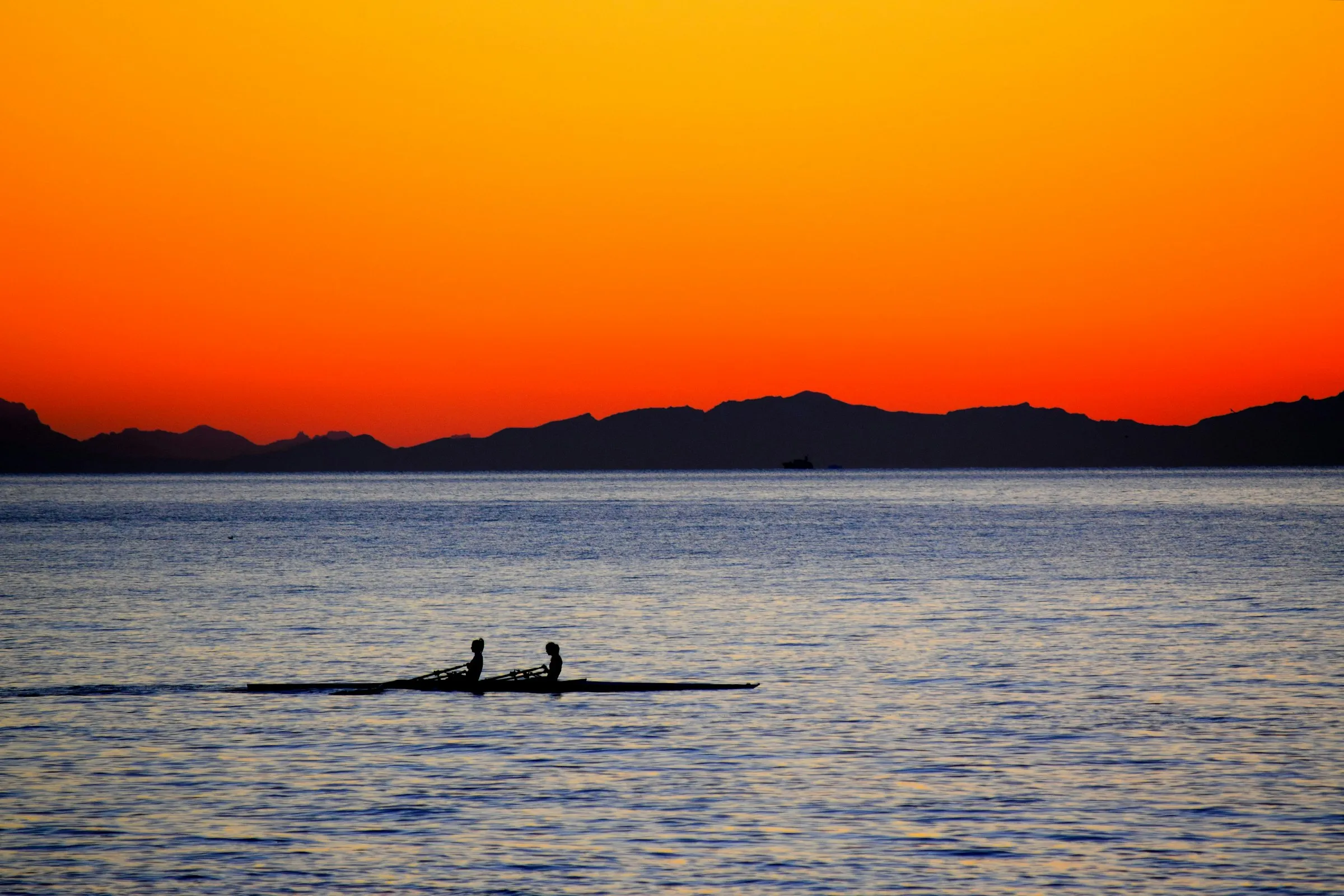 Couple silhouetted on a boat at sunset