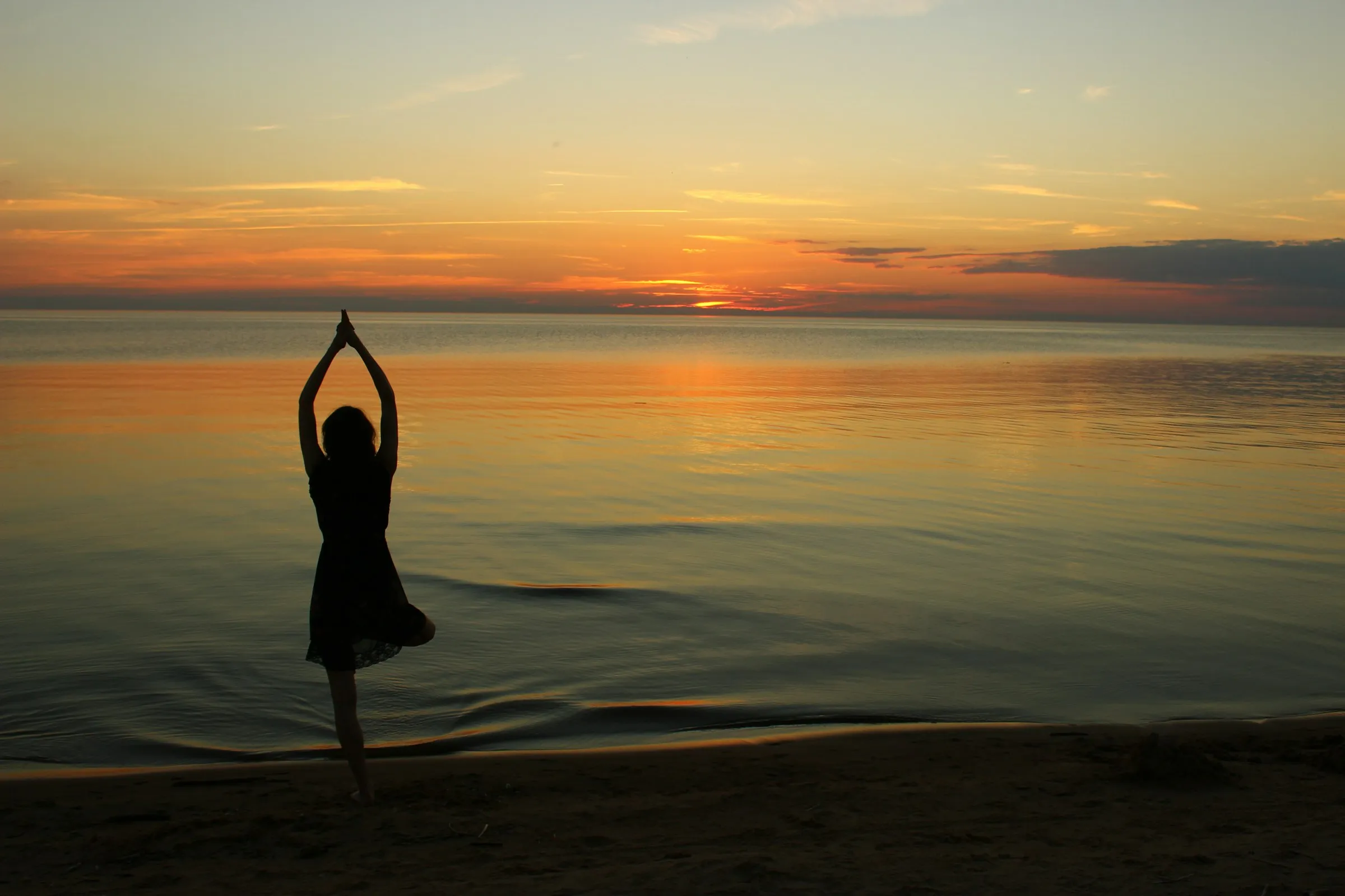 Yoga practice by calm waters at golden hour